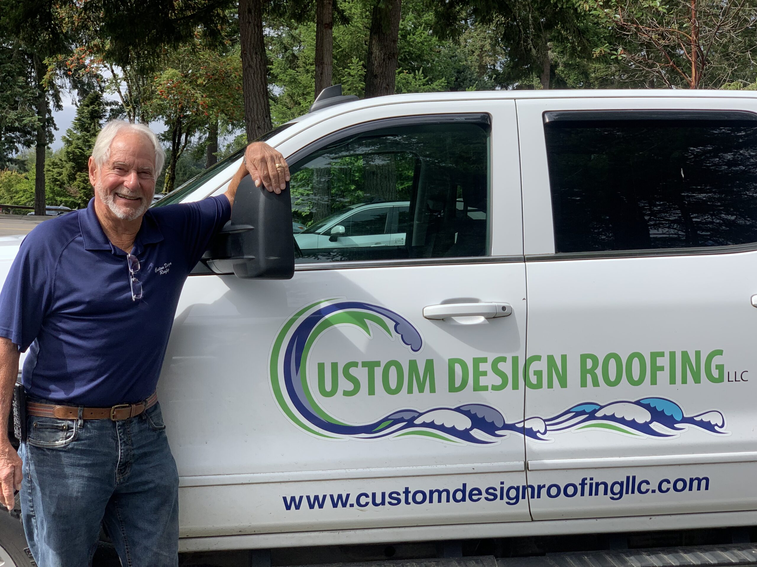 Custom Design Roofing owner standing beside a company truck in Gig Harbor